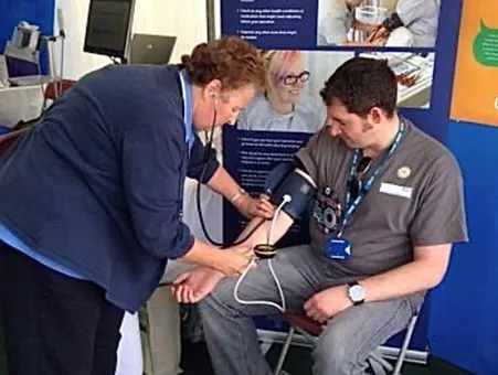 A clinician measuring a person's blood pressure at the Royal Cornwall Show