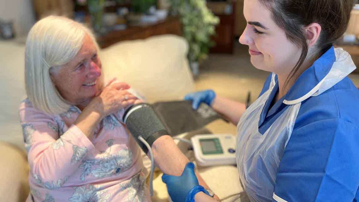 A nurse taking and elderly patient's blood pressure.